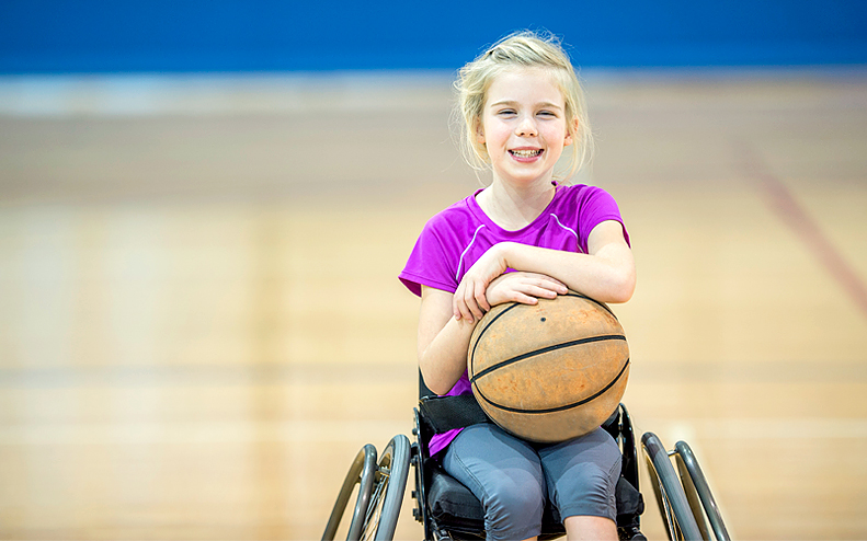 Rullstolsbunden flicka med basketboll