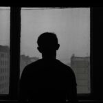 silhouette of man standing near window